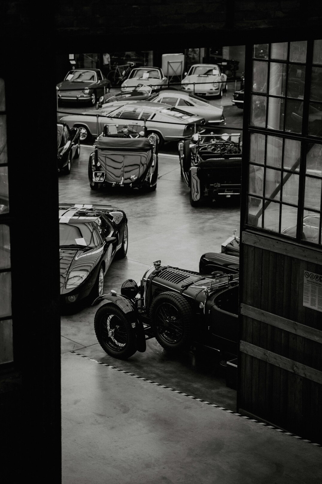 Private collection of classic automobiles inside a dim atmospheric garage