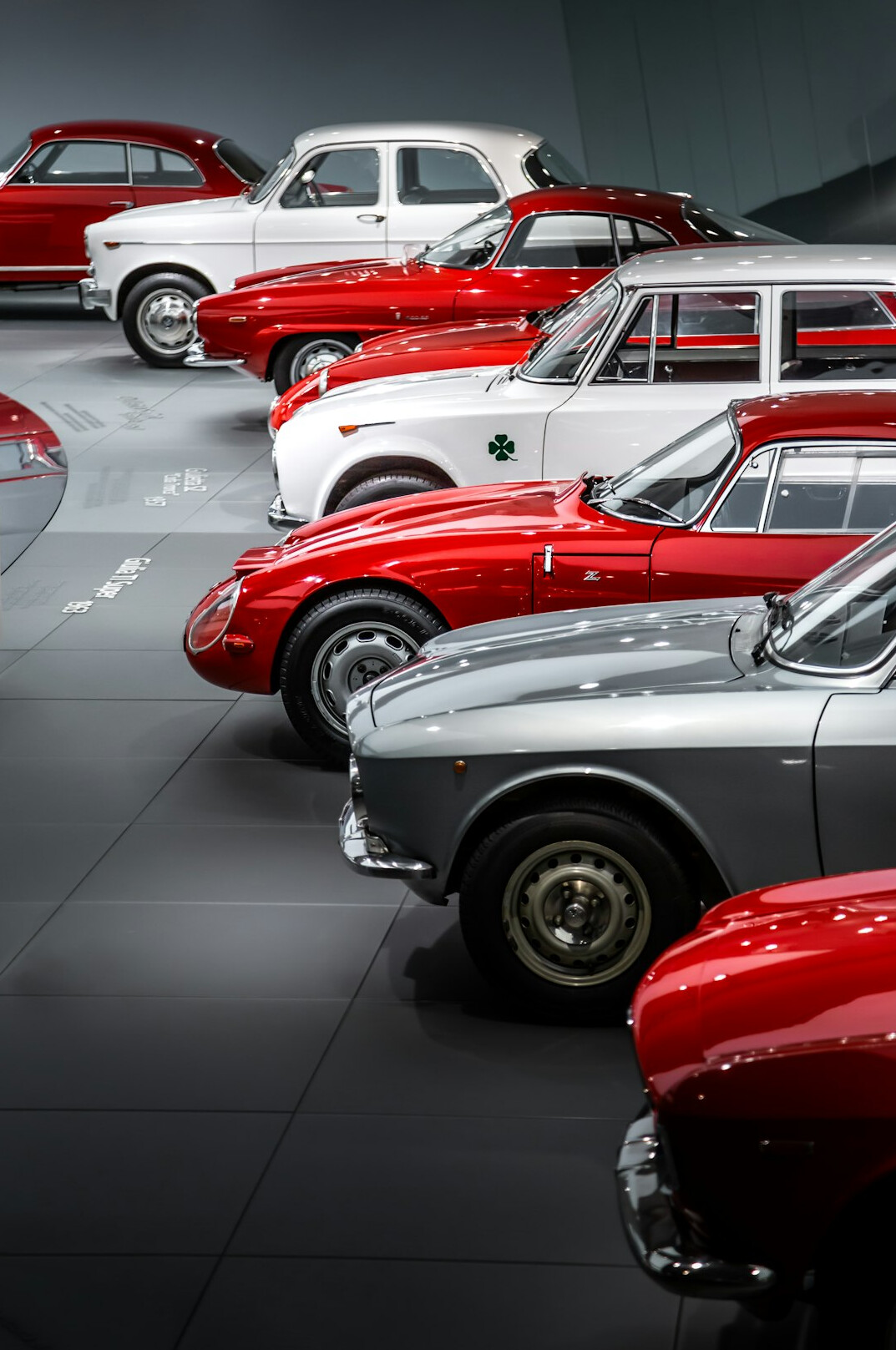 Interior of a classic automobile museum with rows of vintage cars under dramatic lighting